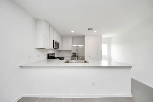 a kitchen with stainless steel appliances granite countertop a stove and a refrigerator