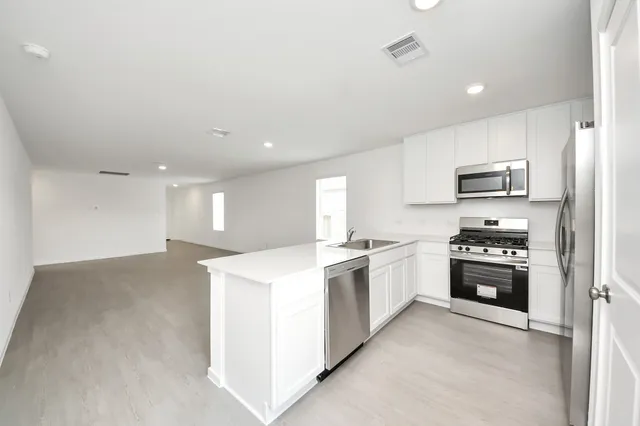 a kitchen with stainless steel appliances a refrigerator and a stove top oven