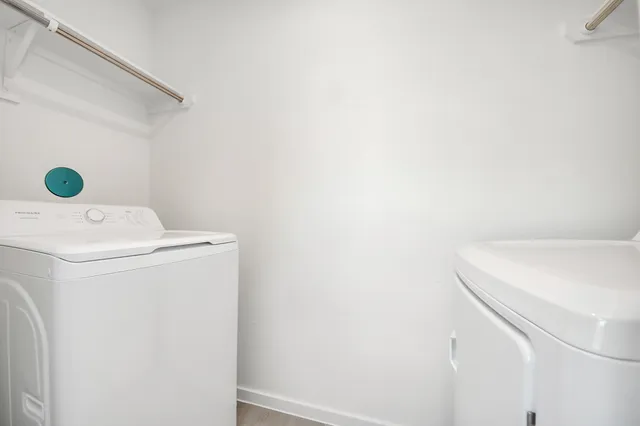a view of a hallway to kitchen with wooden floor