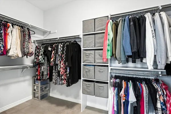 a view of walk in closet with clothes and shoes