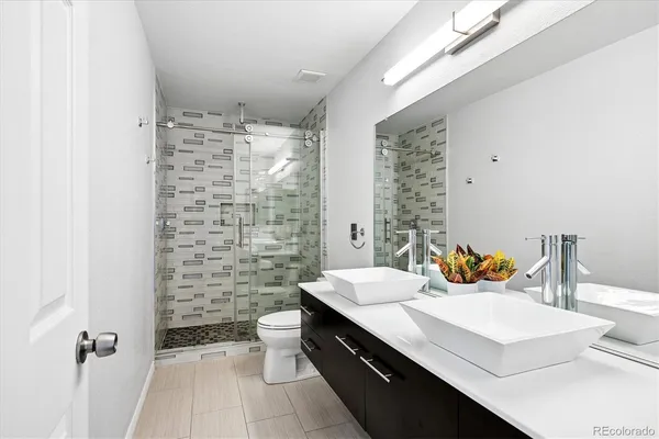 a bathroom with a sink a toilet and shower