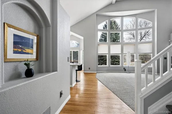 a view of a bedroom with wooden floor and windows
