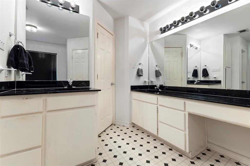 401 Rugged Drive Red Oak, TX 75154 - Photo 23 of 40 Bathroom featuring dual vanity areas with black countertops, white cabinetry, and a black and white tiled floor