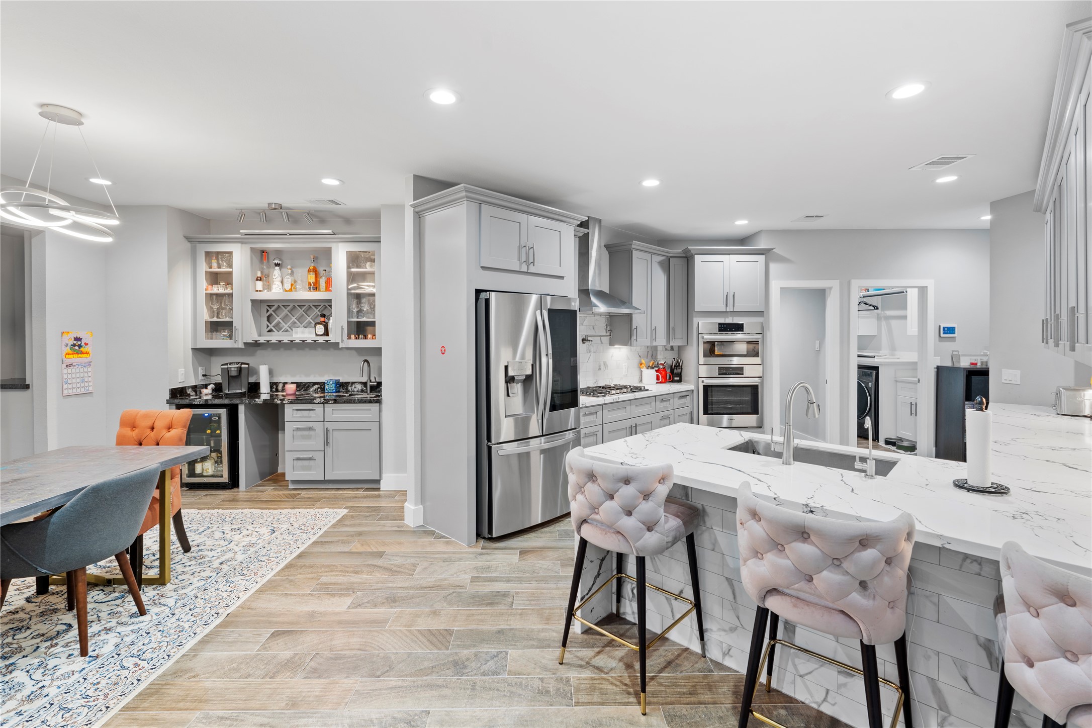 6207 Graff Net Court Spring, TX 77379 - Photo 18 of 49 Gourmet kitchen with breakfast island, dining area with stunning chandelier, and a dedicated bar with sink.