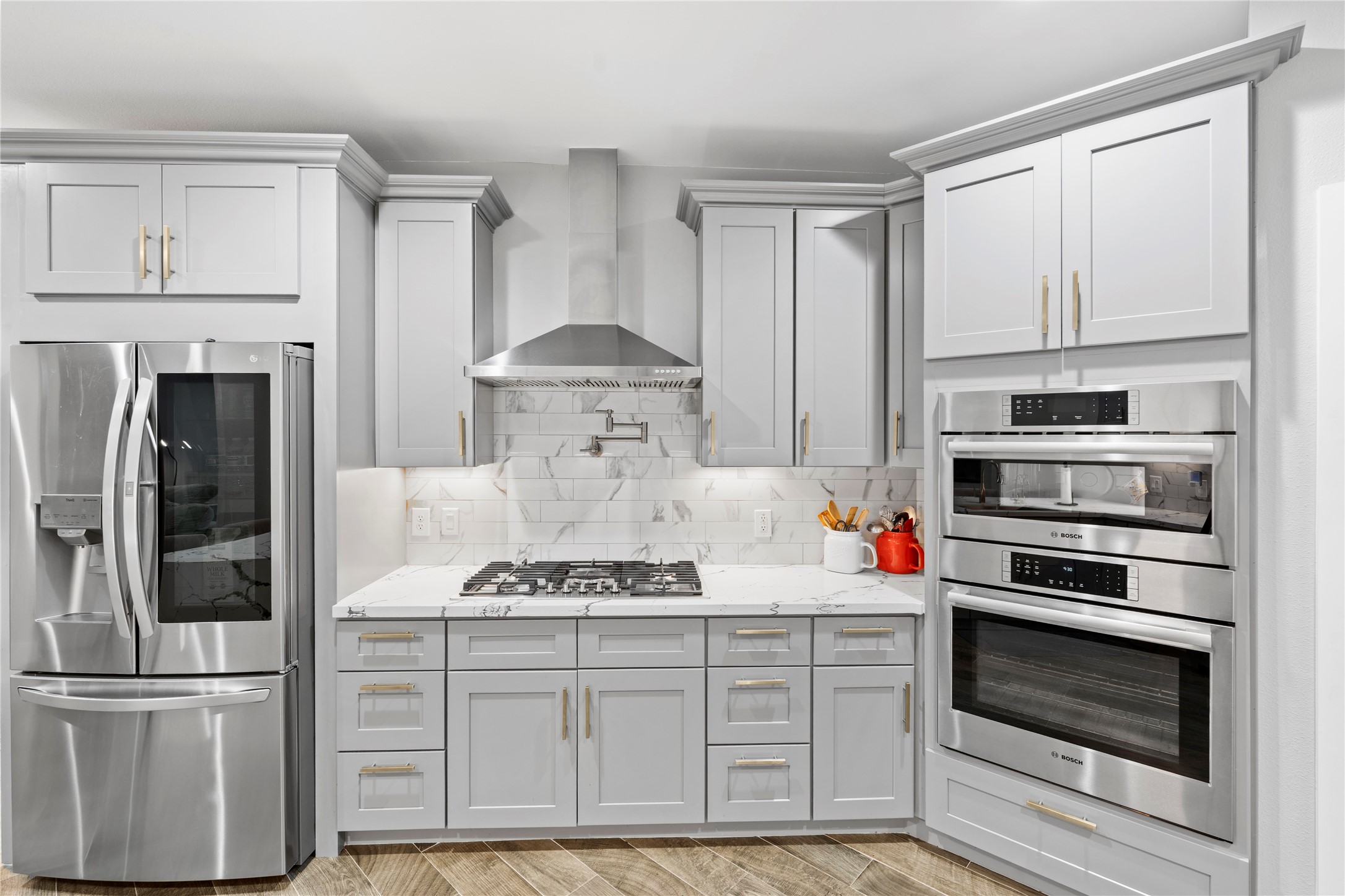 6207 Graff Net Court Spring, TX 77379 - Photo 20 of 49 Stylish cabinets with gold accents, over-the-stove faucet, and high-end stainless steel appliances.