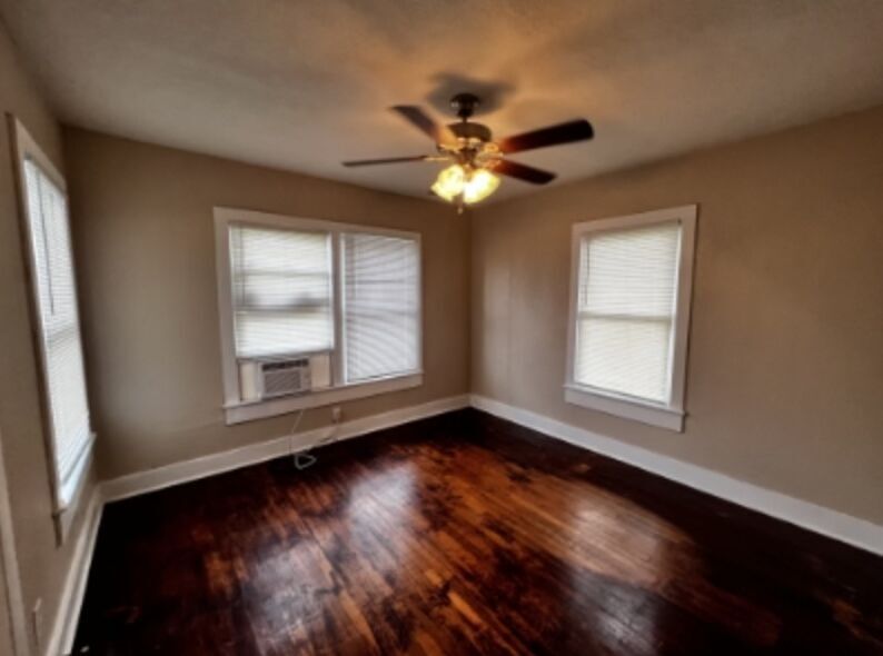 301 Cardinal Street San Marcos, TX 78666 - Photo 7 of 9 Empty room with dark wood-style flooring, cooling unit, ceiling fan, and plenty of natural light