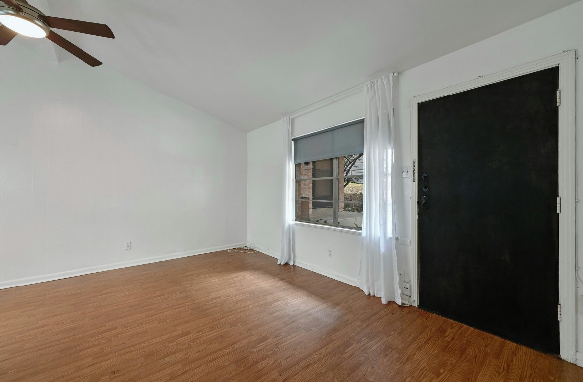 515 Pecan Grove Road, Unit A Austin, TX 78704 - Photo 5 of 17 a view of an empty room with wooden floor and a window