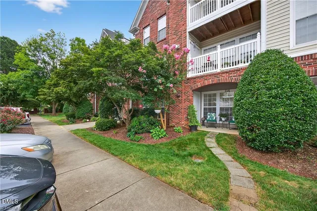 a front view of a house with a yard and potted plants