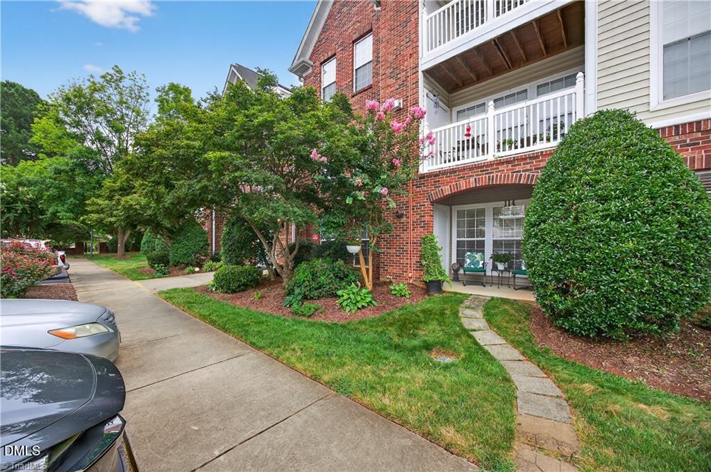 2221 Delaney Drive, Unit 114 Burlington, NC 27215 - Photo 1 of 18 a front view of a house with a yard and potted plants