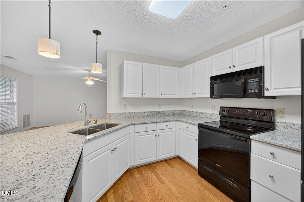 2221 Delaney Drive, Unit 114 Burlington, NC 27215 - Photo 11 of 18 a kitchen with granite countertop stainless steel appliances a stove sink microwave and cabinets