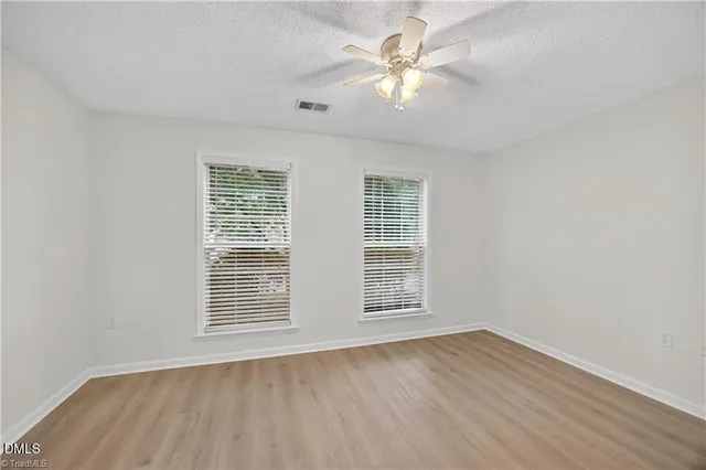 an empty room with wooden floor and window