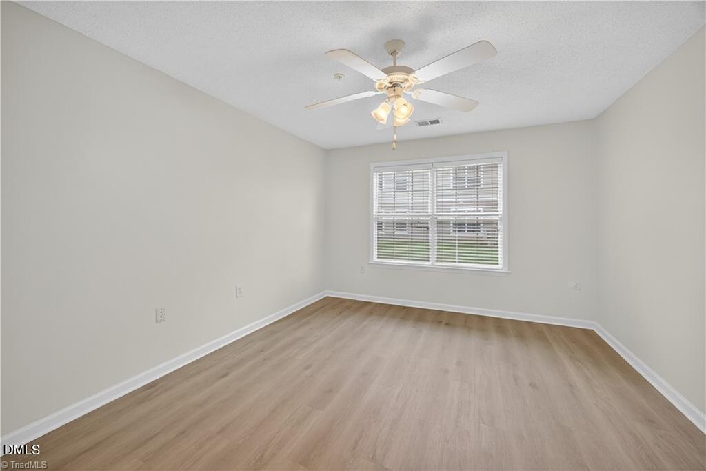 2221 Delaney Drive, Unit 114 Burlington, NC 27215 - Photo 15 of 18 a view of an empty room with wooden floor and a window