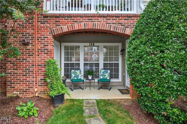 a patio with table and chairs and potted plants
