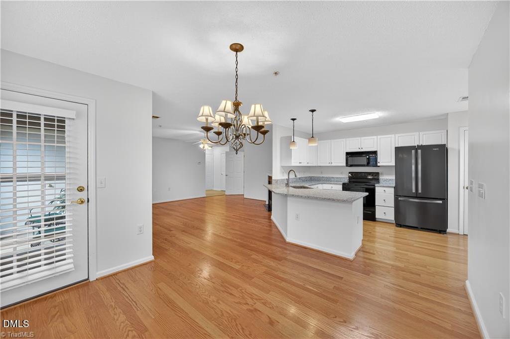 2221 Delaney Drive, Unit 114 Burlington, NC 27215 - Photo 2 of 18 a view of a kitchen with stainless steel appliances granite countertop a stove top oven a refrigerator and a wooden floor