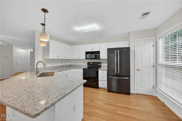 a kitchen with granite countertop a refrigerator oven a sink and dishwasher