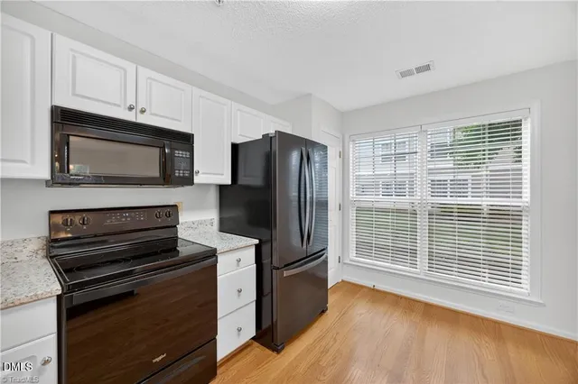 a kitchen with wooden cabinets stainless steel appliances and a window