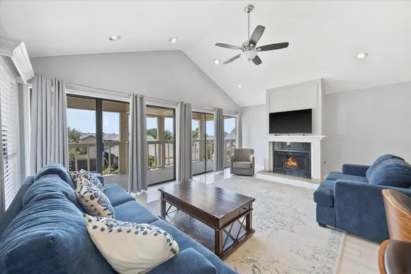 a living room with furniture a fireplace and a floor to ceiling window