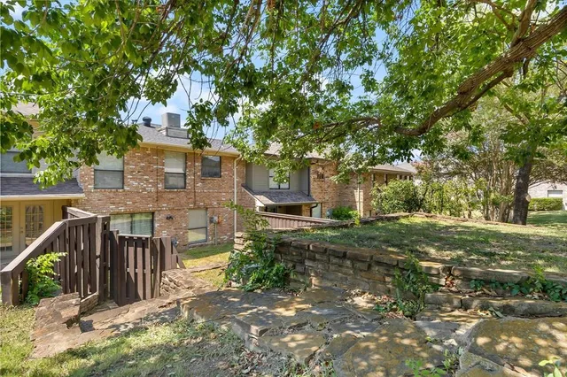 a view of a house with backyard and trees