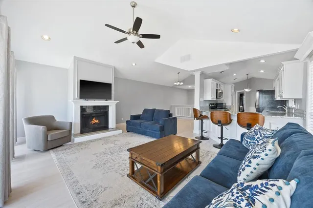 a living room with furniture kitchen view and a fireplace