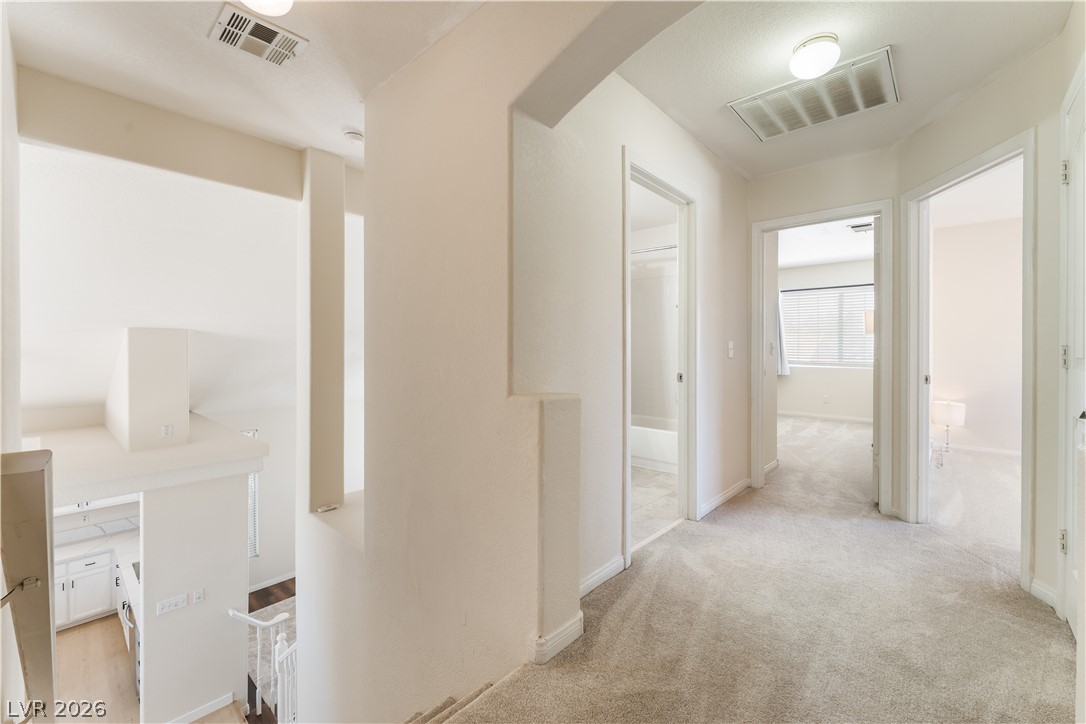8872 Chapman Point Las Vegas, NV 89129 - Photo 12 of 29 A welcoming upper-level hallway with plush carpeting connects to several rooms and overlooks the floor below.