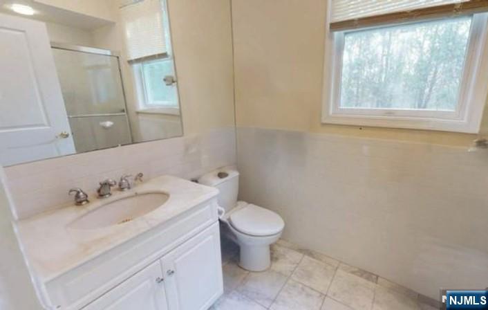 6 Hemlock Lane, Unit 6 Tenafly, NJ 07670 - Photo 7 of 9 a bathroom with a toilet sink and mirror