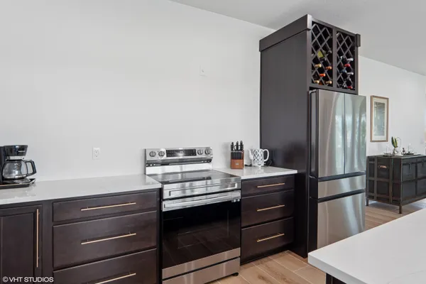 a dining hall with stainless steel appliances kitchen island a table and chairs in it