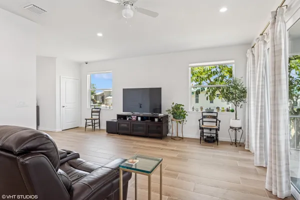 a living room with furniture a flat screen tv and a large window
