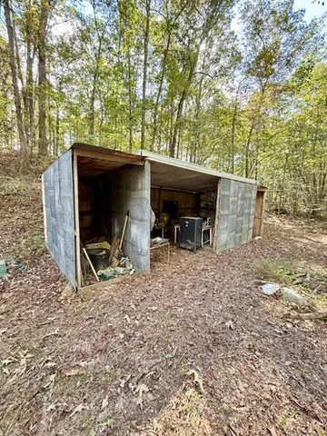 a view of a wooden house with a yard and roof