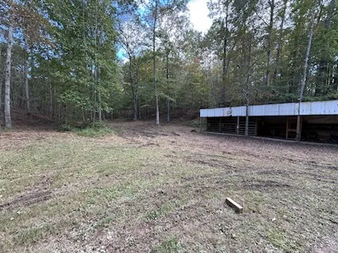 a view of a backyard with table and chairs under an umbrella