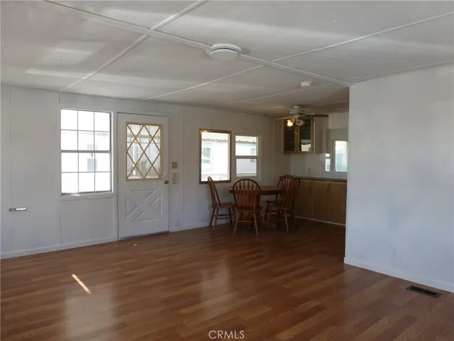 an empty room with wooden floor and furniture