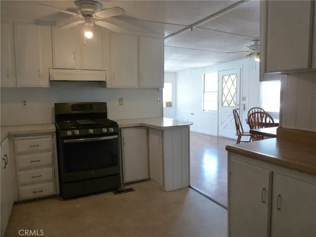a kitchen with granite countertop a stove a cabinets and a sink