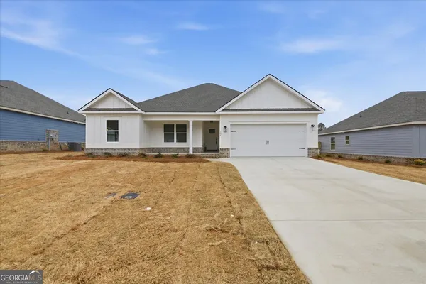 a view of a house with a yard and large tree