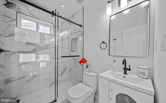 a bathroom with a toilet sink shower and mirror