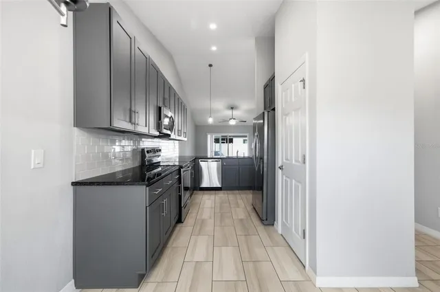 a kitchen with stainless steel appliances granite countertop a refrigerator and a sink