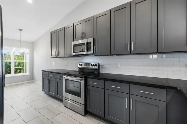 a kitchen with stainless steel appliances granite countertop a stove a sink and a microwave