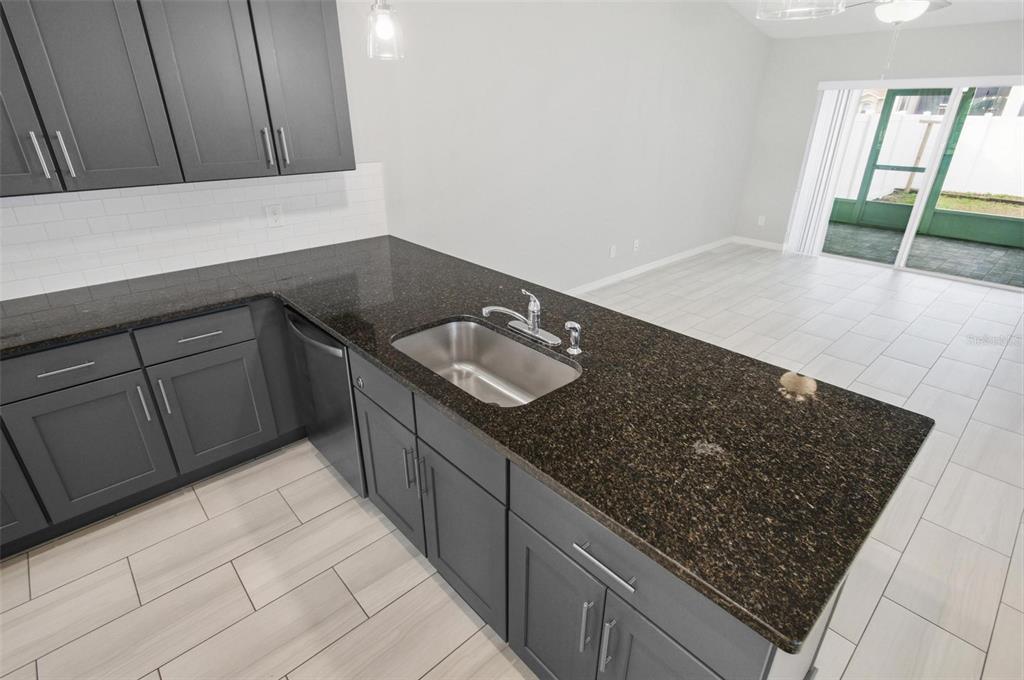2 Lynton Place, Unit B Palm Coast, FL 32137 - Photo 21 of 51 a kitchen with granite countertop a sink and a stove