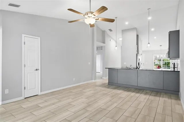 a view of a kitchen with a sink and a chandelier fan