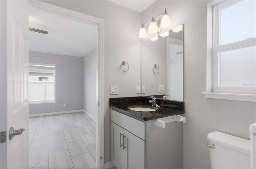 2 Lynton Place, Unit B Palm Coast, FL 32137 - Photo 35 of 51 a bathroom with a granite countertop sink a toilet and a mirror