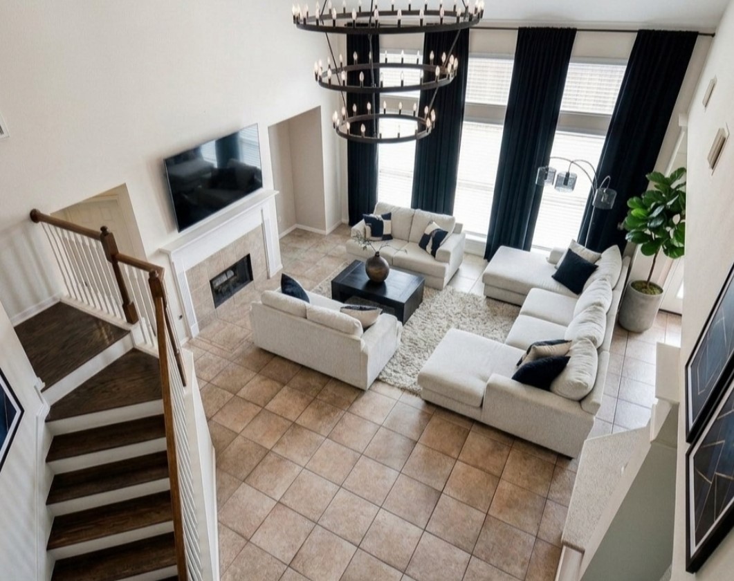19802 Shavon Springs Drive Spring, TX 77388 - Photo 8 of 30 Virtullay staged living room setup idea high ceilings, a cozy fireplace, and an elegant chandelier—perfect for relaxation and entertaining