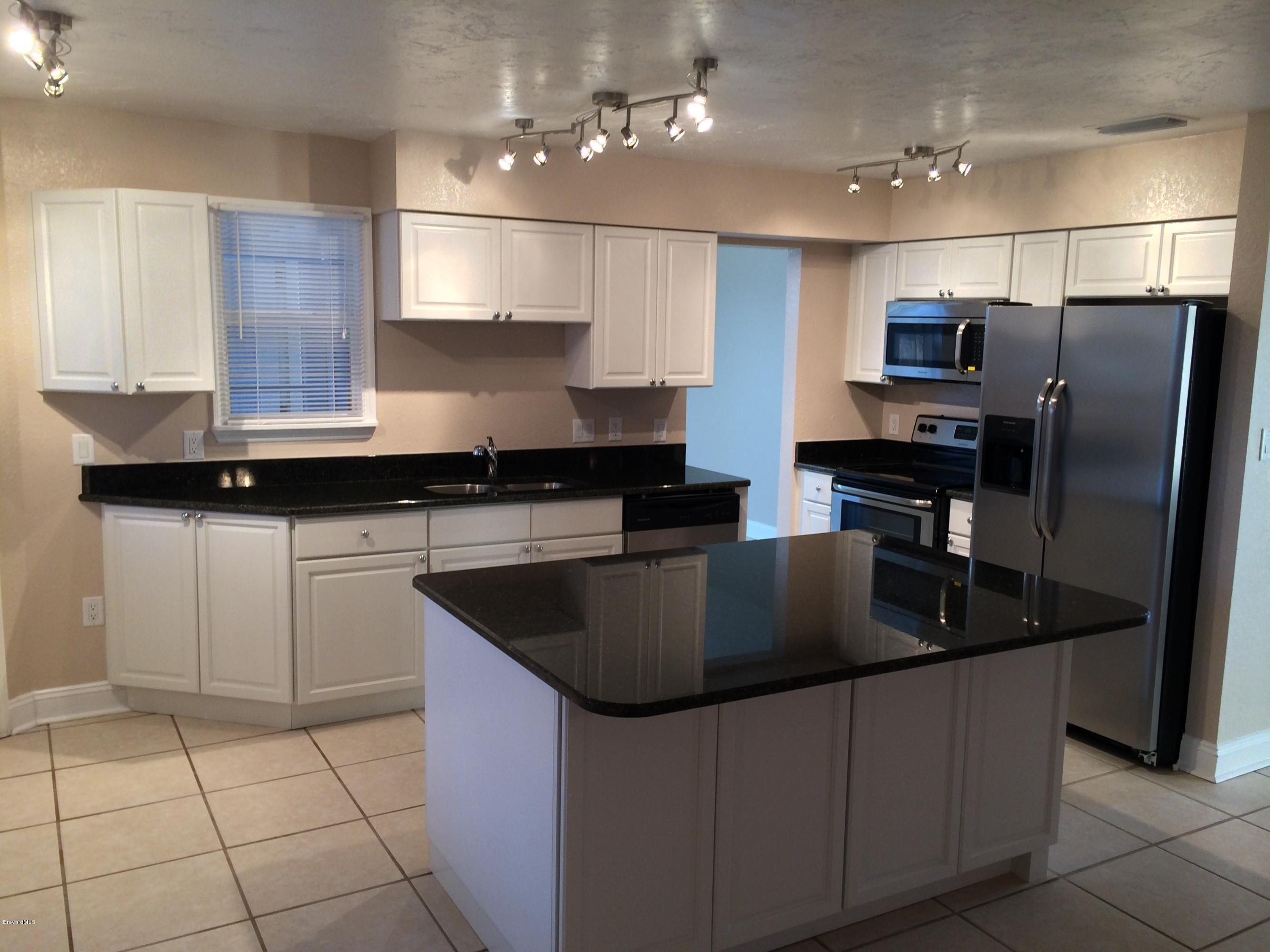 6151 Corning Road Cocoa, FL 32927 - Photo 7 of 13 a kitchen with stainless steel appliances granite countertop a sink a stove and refrigerator