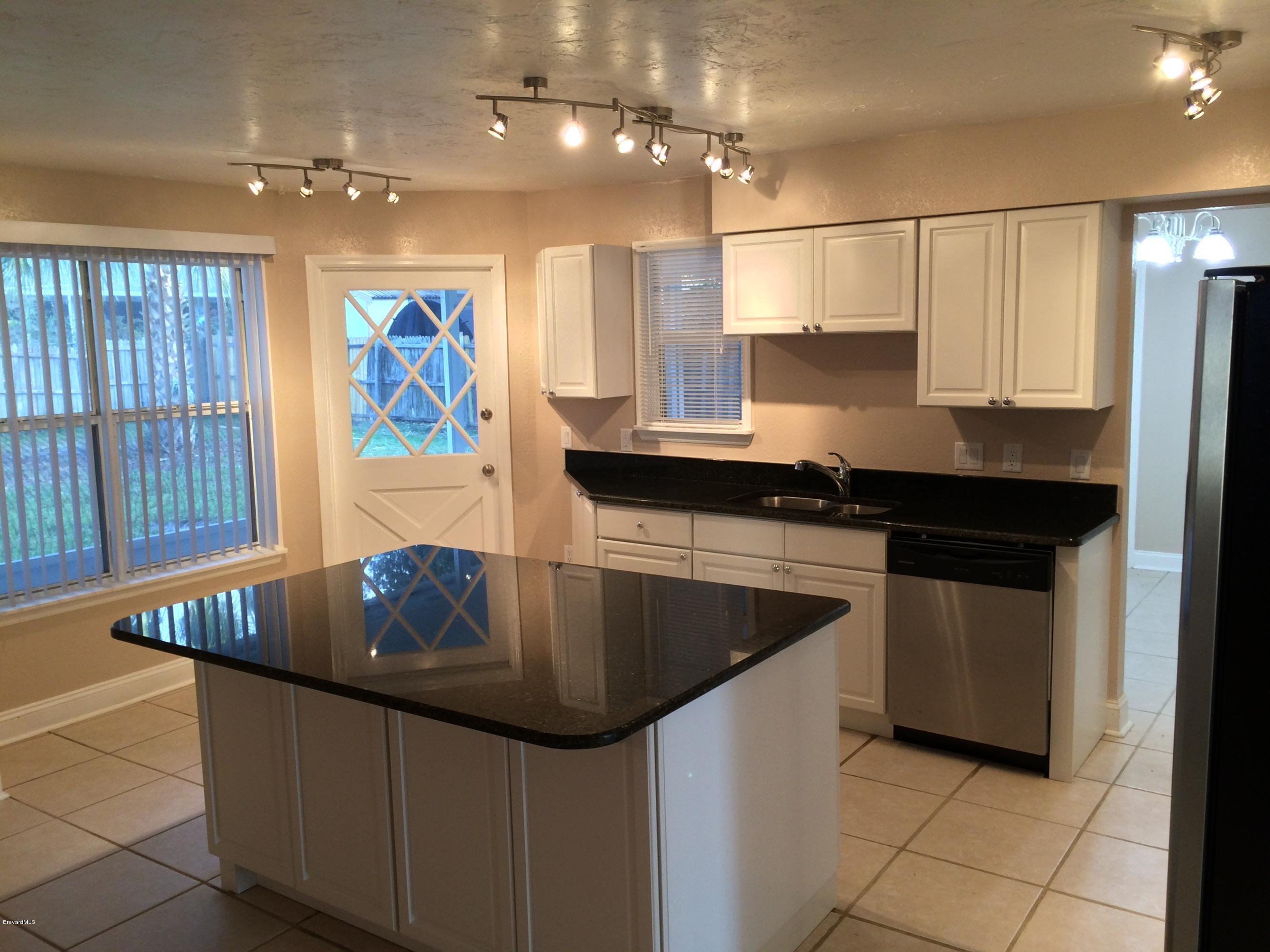 6151 Corning Road Cocoa, FL 32927 - Photo 9 of 13 a kitchen with stainless steel appliances granite countertop a sink and a refrigerator