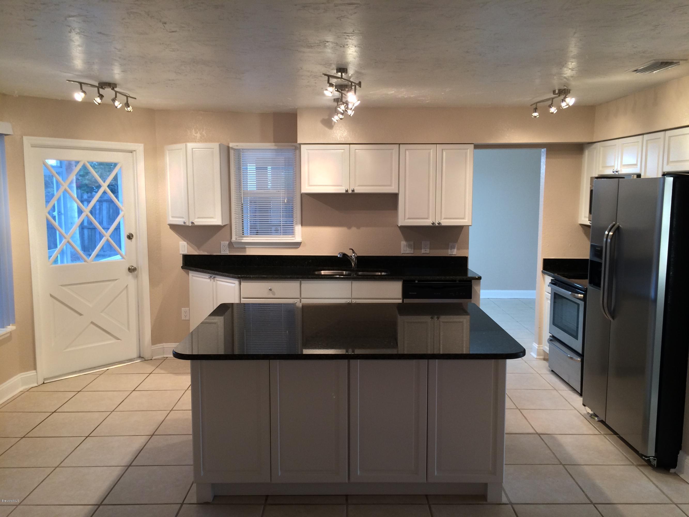 6151 Corning Road Cocoa, FL 32927 - Photo 10 of 13 a kitchen with kitchen island granite countertop a stove and a refrigerator