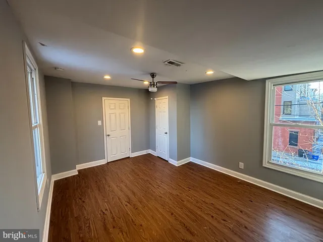 an empty room with windows and closet