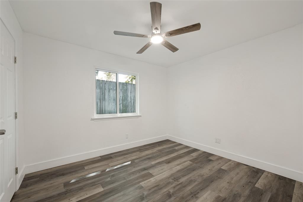 3004 Raintree Court Bedford, TX 76021 - Photo 20 of 25 Wood-finish flooring, white walls, ceiling-mounted fan with integrated lighting, and a white-framed window