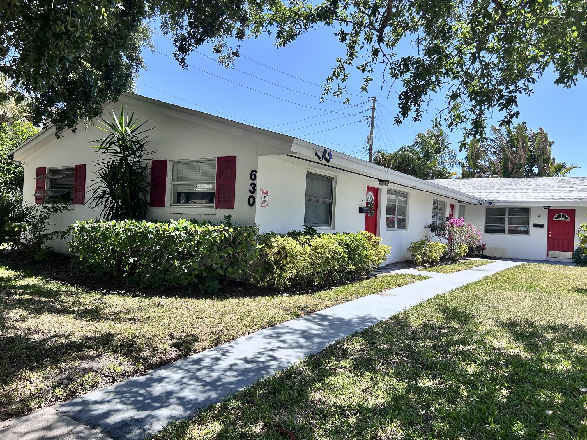 630 Prosperity Farms Road, Unit 2 North Palm Beach, FL 33408 - Photo 4 of 13 a front view of house with yard and trees around