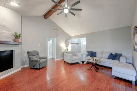 a living room with furniture and a wooden floor