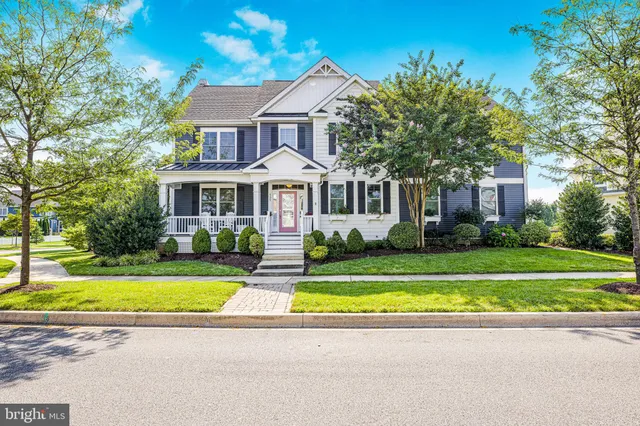 a view of a house with a big yard plants and large trees
