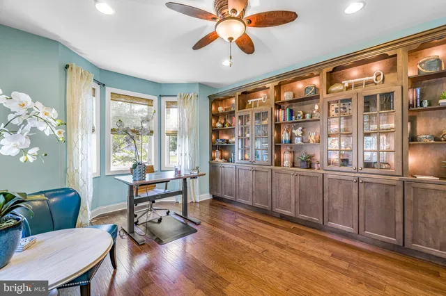 an empty room with windows and ceiling fan