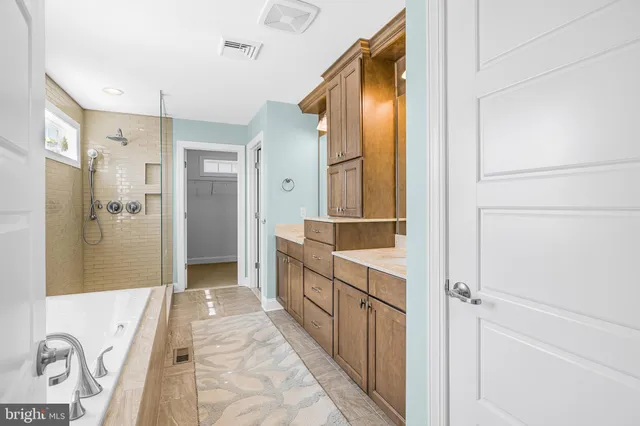 a bathroom with a shower a sink mirror and toilet