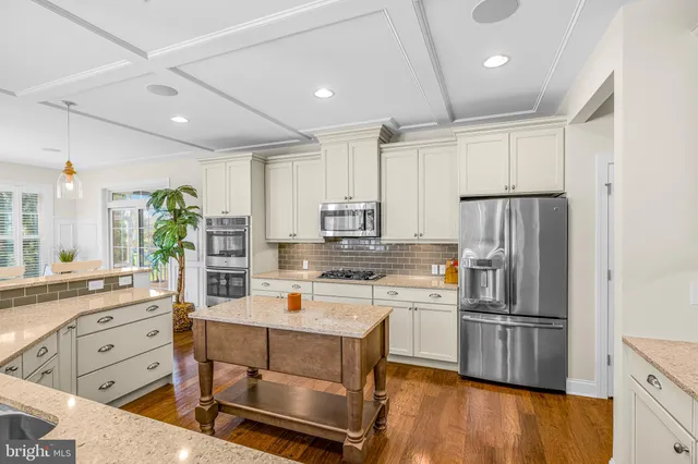 a kitchen with stainless steel appliances white cabinets and a stove top oven
